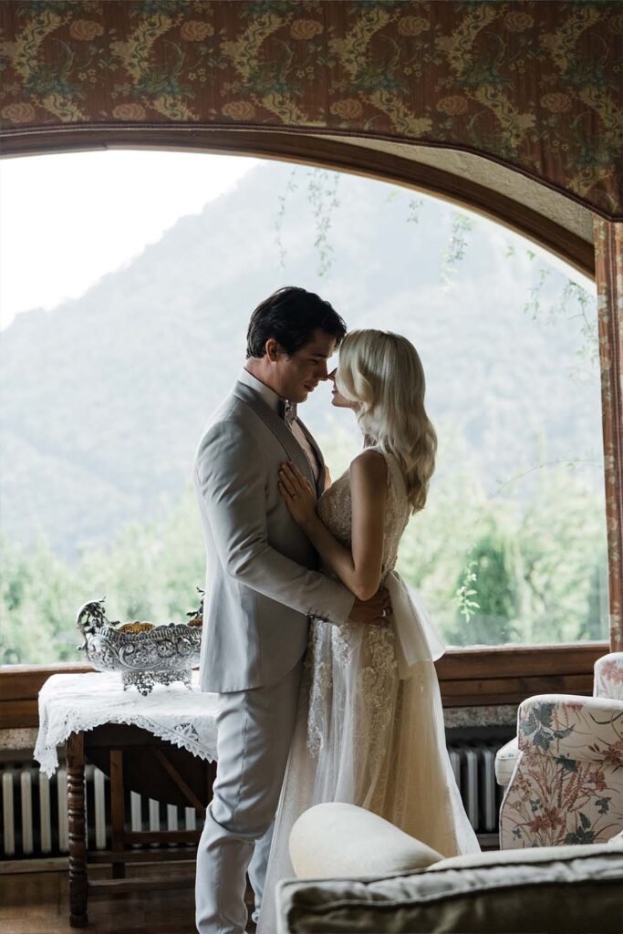 The bride and groom embrace and lean in for a kiss