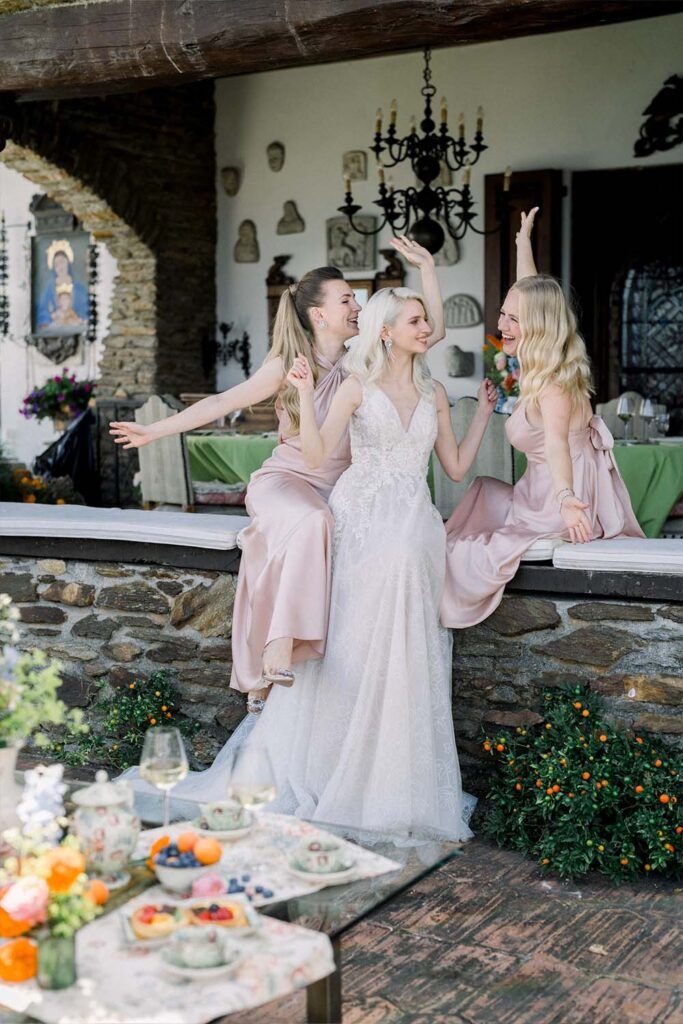 Three girls sit smiling and celebrating a wedding.