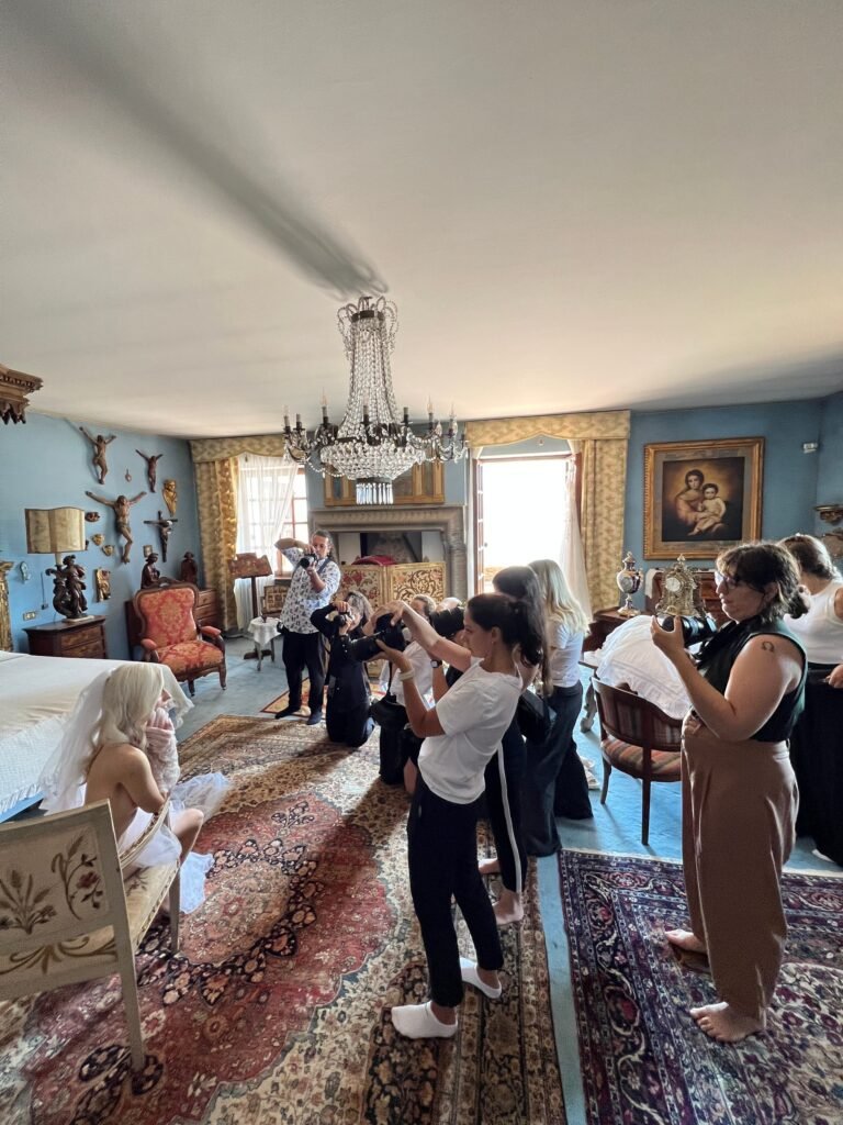 A group of participants photographing a model in a decorated room