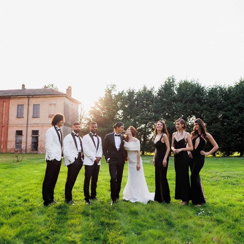 A couple celebrates their wedding surrounded by their friends in the garden against the backdrop of a castle