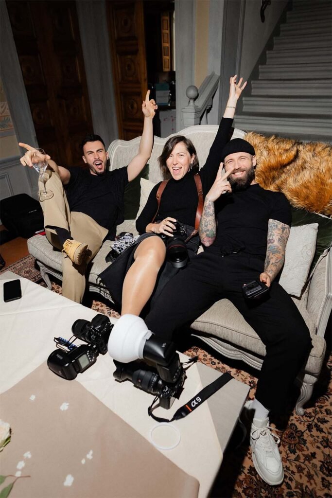 3 photographers enjoying the work done sitting on the couch with cameras on the table