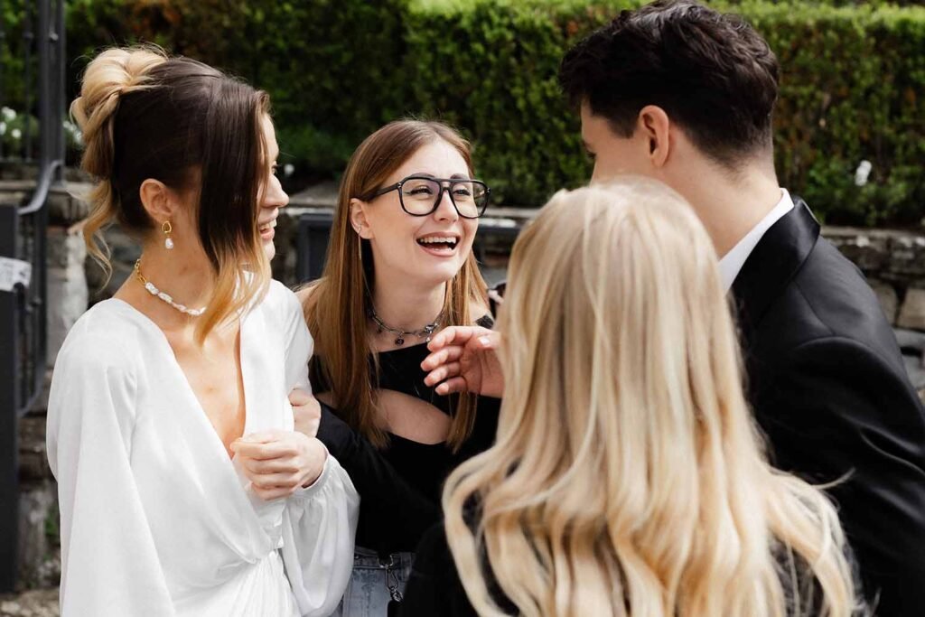 Models socialize and laugh with other event attendees in the garden