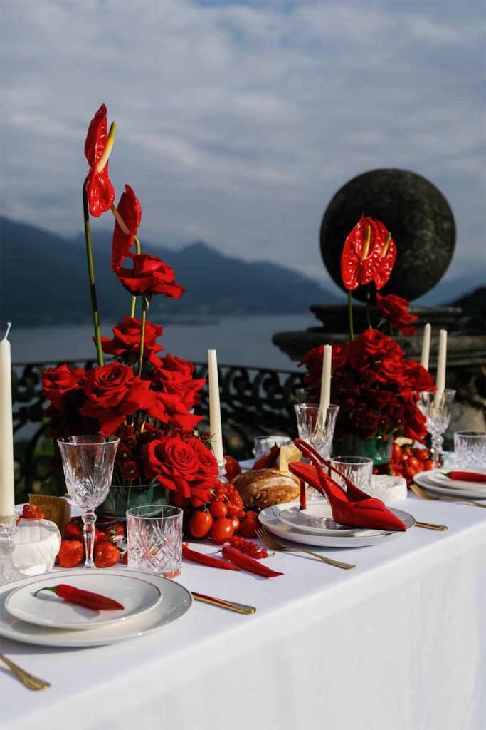 Table with red decorations on the background of the mountains of Lake Como