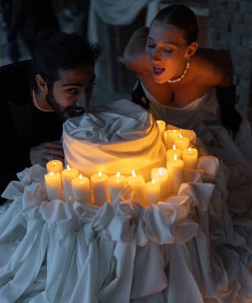 The bride and groom blow out the candles on the cake